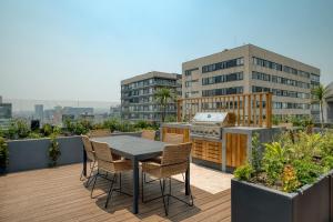 eine Terrasse mit einem Tisch und Stühlen auf dem Dach in der Unterkunft Nido at Gran Ciudad Nuevo Polanco in Mexiko-Stadt