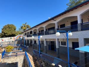a building with blue benches in front of it at Nova Aliança Suítes por Temporada em Amparo NÃO SOMOS POUSADA in Amparo