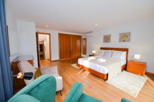 a bedroom with a bed and a living room at Casa do Cantinho do Muro in São Vicente