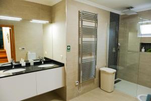 a bathroom with two sinks and a shower at Casa do Cantinho do Muro in São Vicente +25 photos