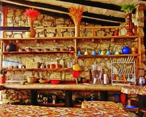 a room with a stone wall with shelves with pots at Casa Grande Sidarta 3 alcobas - Casita pequena 2 alcobas in Chocontá
