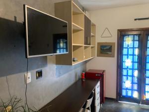 a kitchen with a counter with a tv on the wall at Casa Azul in Niterói