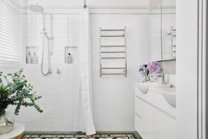a white bathroom with a shower and a sink at Bendigo Signature Accommodation Wattle Street in Bendigo +19 photos
