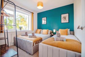twee bedden in een kamer met blauwe muren bij Open Haven Collective with Man Cave and Parking 10PPL in Handsworth