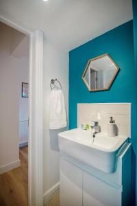 een badkamer met een witte wastafel en een spiegel bij Open Haven Collective with Man Cave and Parking 10PPL in Handsworth +88 foto's