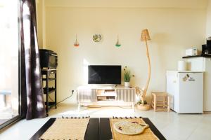 - un salon avec une télévision et un réfrigérateur blanc dans l'établissement Argan Oasis Studio, Poolside Retreat near Taghazout, à Ikouzza