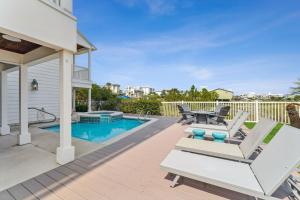 une terrasse avec des chaises, une table et une piscine dans l'établissement Dock N Dune by 30A Escapes, à Seagrove Beach