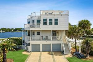 une maison au bord de l'eau avec des palmiers dans l'établissement Dock N Dune by 30A Escapes, à Seagrove Beach