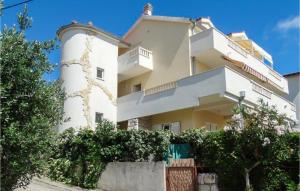 a white building with trees in front of it at Cozy Apartment In Omis With House Sea View in Tice