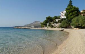 a sandy beach with houses and the ocean at Cozy Apartment In Omis With House Sea View in Tice +5 photos