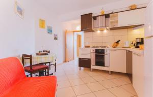 a kitchen and dining room with a red couch and a table at Cozy Apartment In Omis With House Sea View in Tice