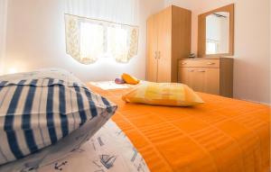 a bedroom with an orange bed with two pillows on it at Cozy Apartment In Omis With House Sea View in Tice