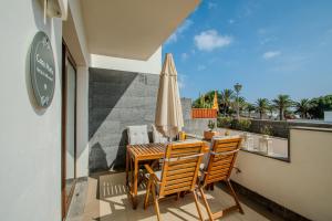 a balcony with a table and chairs and an umbrella at Casa Marla by Villalize in Puerto Calero