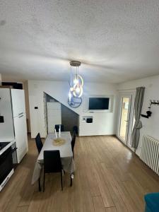 a dining room with a table and a chandelier at Lake Apartment Gold, Lago di Caldonazzo in Tenna 