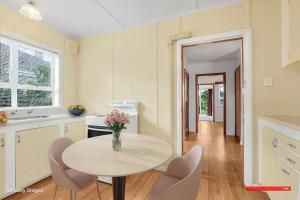 een keuken met een witte tafel en stoelen en een tafel bij Boxed Bliss on Fox in Hamilton