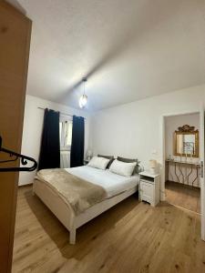 a bedroom with a large white bed and a mirror at Lake Apartment Gold, Lago di Caldonazzo in Tenna 
