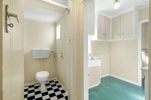 een badkamer met een toilet en een geruite vloer bij Boxed Bliss on Fox in Hamilton