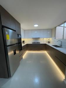 een lege keuken met een koelkast en een wastafel bij Casa Terminal Terrestre in Loja