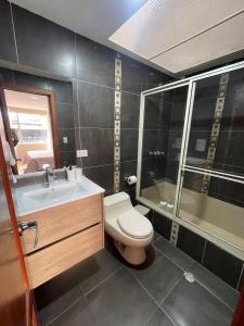 een badkamer met een toilet, een wastafel en een douche bij Casa Terminal Terrestre in Loja +7 foto's