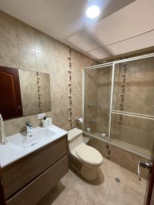 een badkamer met een toilet, een wastafel en een douche bij Casa Terminal Terrestre in Loja