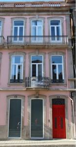 un bâtiment rose avec une porte rouge et des fenêtres dans l'établissement 12 Short Term, à Porto