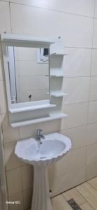 un bagno con un lavandino bianco e uno specchio di Iline residence a Jijel