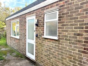 a brick building with two windows and a door at Worthing - Garden Pad with FREE on street PARKING in Worthing +4 photos