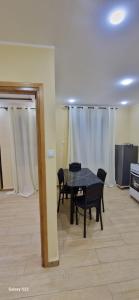 una sala da pranzo con tavolo e sedie neri di Iline residence a Jijel