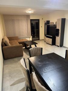 a living room with a table and a couch at Квартира in Kozloduy