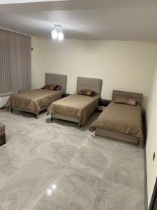 2 Betten in einem Zimmer mit Marmorboden in der Unterkunft Квартира in Kozloduy