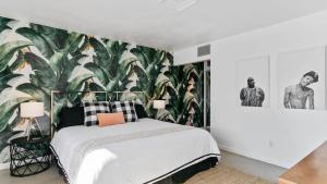 a bedroom with a large bed with a tropical wallpaper at The Marley by AvantStay in Palm Springs +24 photos