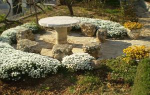 a stone bench in a garden with white flowers at Lovely Apartment In Omis With Wifi in Tice +13 photos