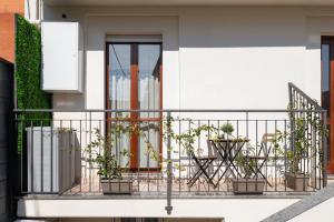 a balcony with potted plants on a building at Elegant Urban Home - Free Parking - 7min Niguarda in Bresso