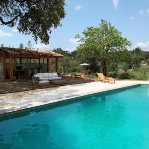 a swimming pool in front of a house at Quinta Revira Volta in Nesperal