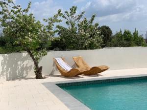 two lounge chairs sitting next to a swimming pool at Quinta Revira Volta in Nesperal