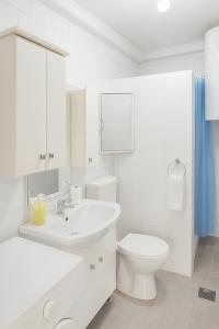a white bathroom with a sink and a toilet at Vila Petunija in Sjenica