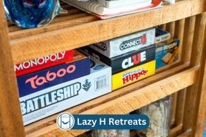 ein Stapel Bücher auf einem Holzregal in der Unterkunft Waterfront Shared Pool Games Winter Family Deals in Padre Island