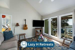 ein Wohnzimmer mit Couch und Flachbildfernseher in der Unterkunft Waterfront Shared Pool Games Winter Family Deals in Padre Island