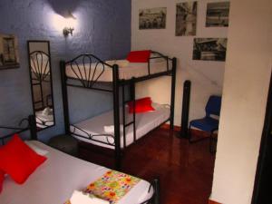 Melao Hostel Campestre y Vivero في بالميرا: غرفة بسريرين ذو طابقين مع وسائد حمراء