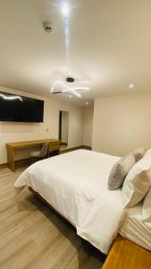 a bedroom with a large white bed and a desk at Saya Hotel & Suites in Cuenca +8 photos