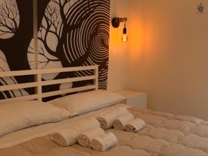 a bed with towels on it with a tree mural at Nido Madreperla in Taranto