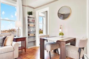 a living room with a table and a mirror at Downtown at the Derenne in Savannah