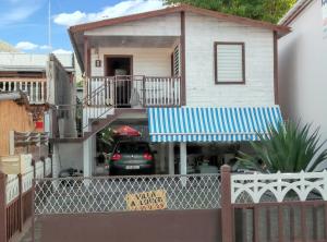 a house with a car parked in front of it at Maison spacieuse et charmante aux Anses-d'Arlet avec vue sur mer in Les Anses-dʼArlets +2 photos