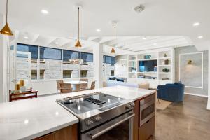 a kitchen with a stove and a living room at Liberty Mid-Century in Savannah