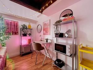 a living room with a table and a microwave at Blush Heaven - Wifi - Netflix in Nancy +9 photos