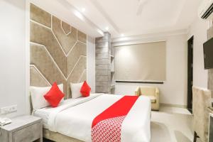 a bedroom with a large bed with red pillows at Hotel O Lax in New Delhi +76 photos