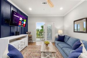 ein Wohnzimmer mit einer blauen Couch und einem Fernseher in der Unterkunft Close to River Shared Family Pool Wurstfest Ready in Gruene