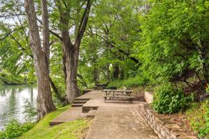 グルーエーヌにあるClose to River Shared Family Pool Wurstfest Readyのベンチと木々のある川沿いの小道