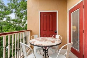 a table and chairs on a balcony with a red door at Close to River Shared Family Pool Wurstfest Ready in New Braunfels
