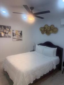 une chambre avec un lit blanc avec un ventilateur de plafond dans l'établissement cozy casa colorado, à Las Vegas 17 autres photos